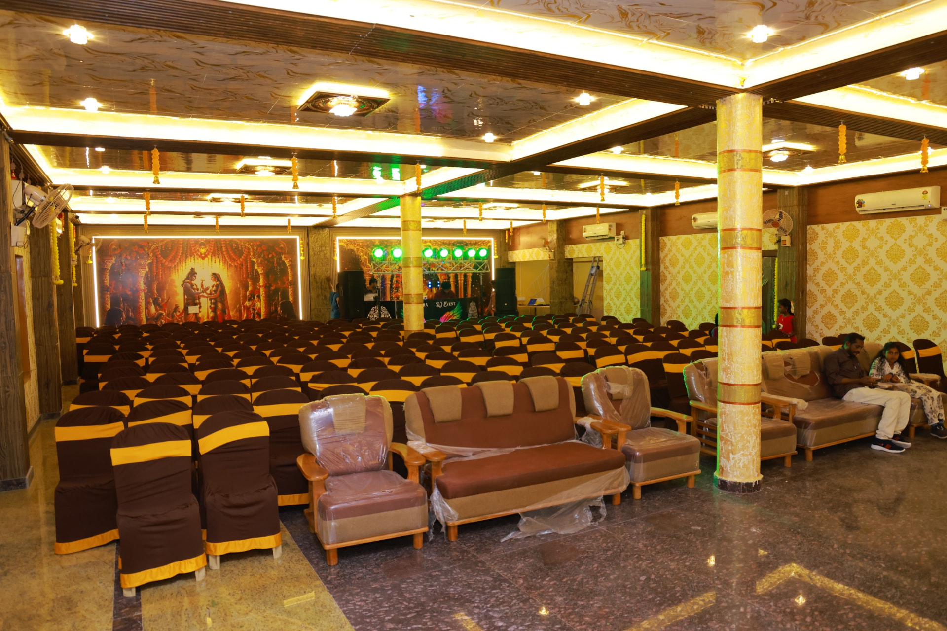 Fully air conditioned convention hall with golden lighting and guest seating in Tiruttani